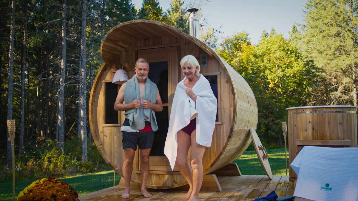 Couple stepping out of a Dundalk LeisureCraft cedar barrel sauna