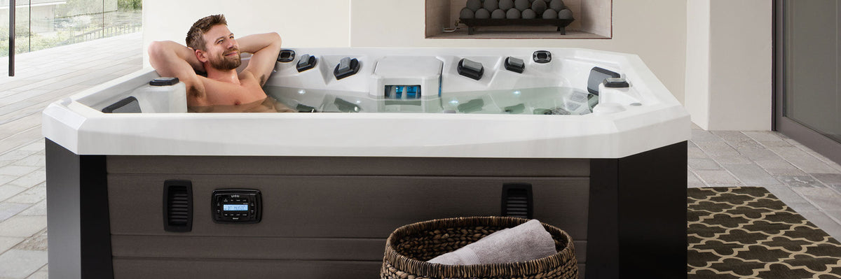 Man relaxing in a Marquis hot tub during a test soak, from The Man Cave Store in Norcross, GA